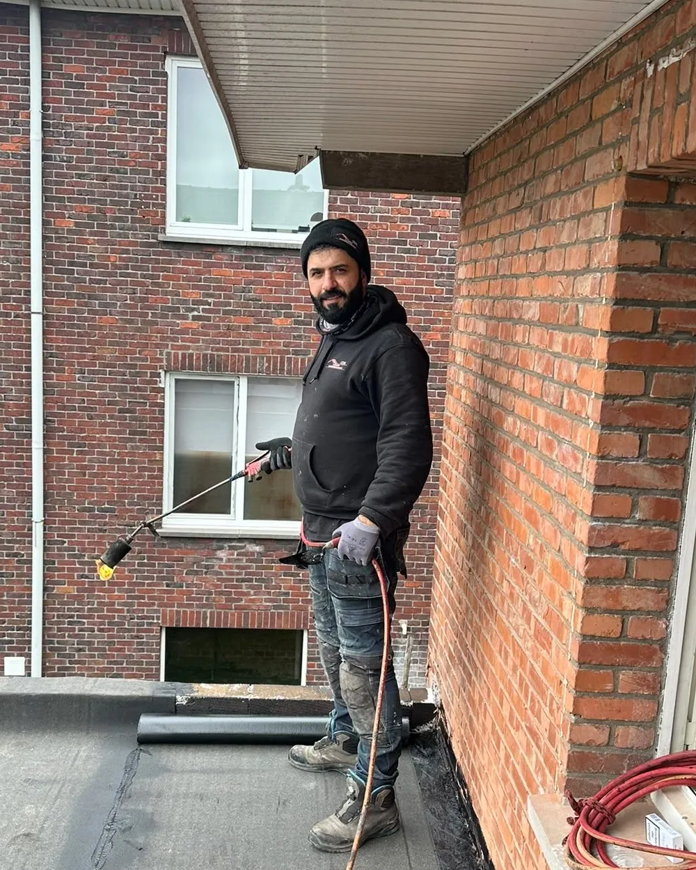 Ciya Ismet, zaakvoerder van Ciya Dakwerken, met brander op een plat dak