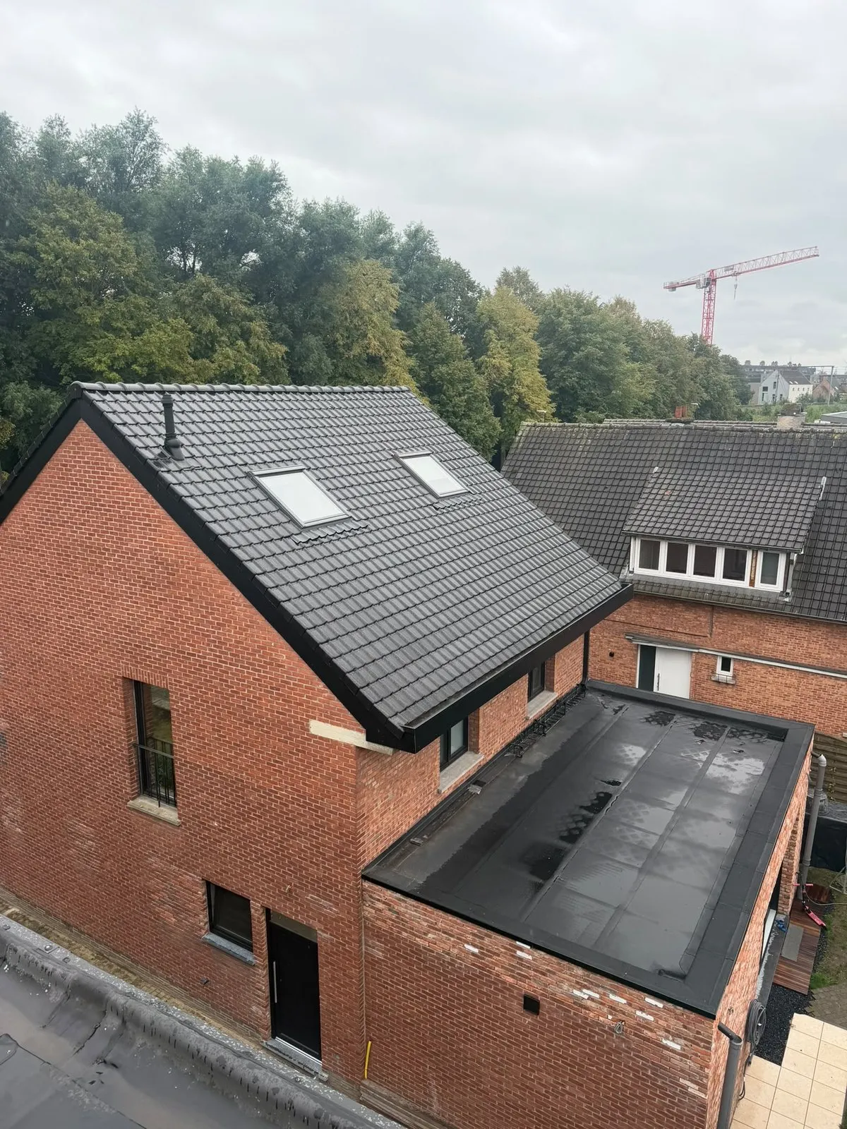 Woning met nieuw plat dak op de aanbouw en dakramen in het hellende dak