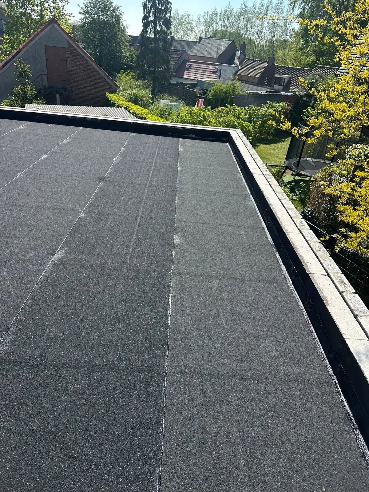 Nieuwe roofing op een plat dak in de zon, met afgewerkte dakrand