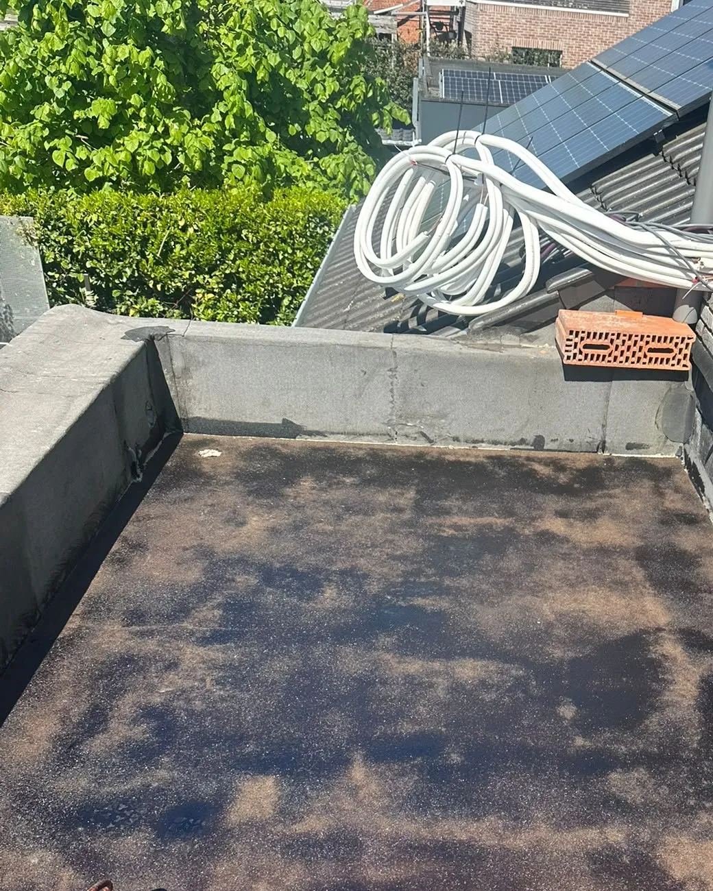 Verouderde, verweerde dakbedekking op een plat dak voor de renovatie