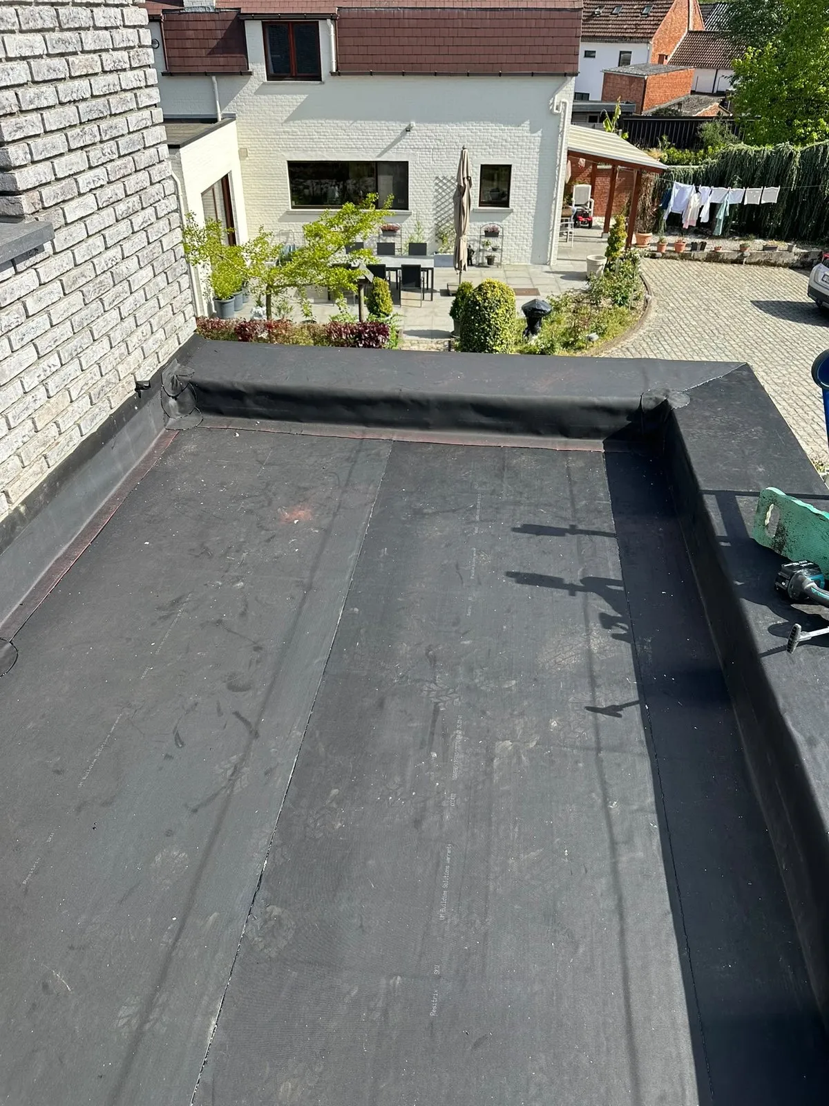 Afgewerkt plat dak met roofing, zicht op de tuin
