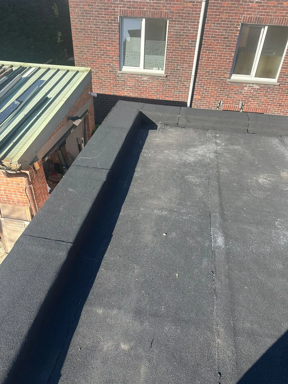 Plat dak met nieuwe roofing tussen twee gebouwen
